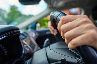 Cropped hand of man driving car