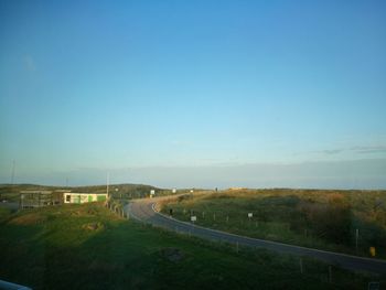 Road against clear blue sky