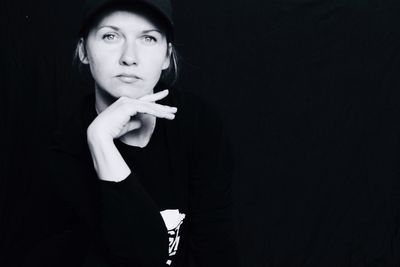 Portrait of a beautiful young woman against black background