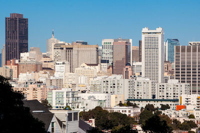 Buildings in city against clear sky