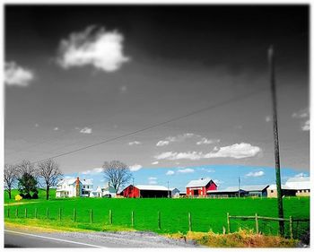 View of field against cloudy sky