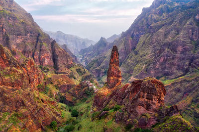 Scenic view of mountain range against cloudy sky