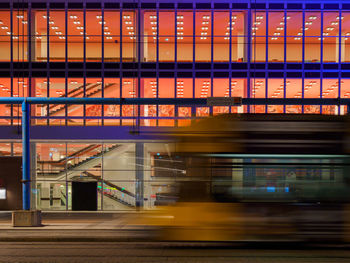 Blurred motion of train in front of dresden concert hall at night