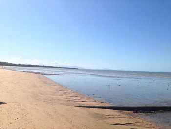 Scenic view of beach against clear blue sky