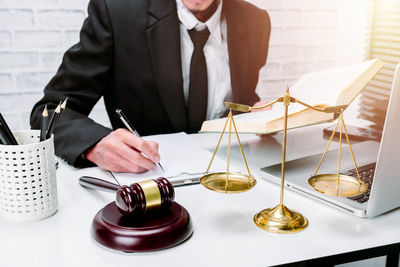 Midsection of a man holding glass table