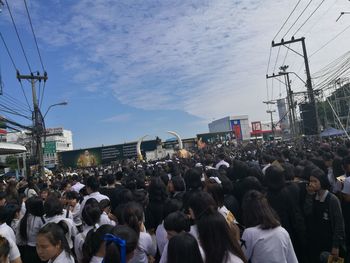 Crowd at low angle view of people against sky