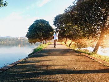 Rear view of woman walking by lake