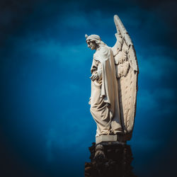 Low angle view of angel statue against sky