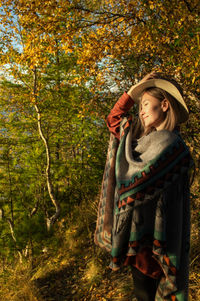 Girl wearing hat standing against plants