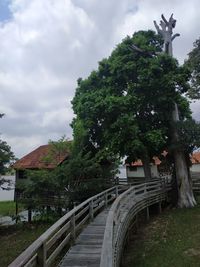 Bridge amidst trees and building against sky