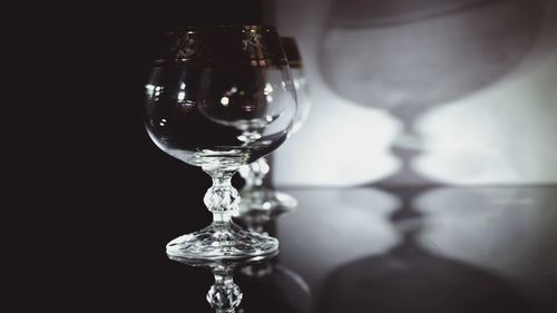 Close-up of wine glass on table against black background