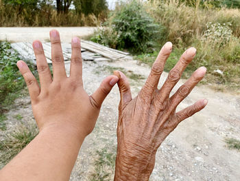 Close-up of human hand against blurred trees