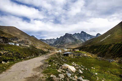 Road by mountains against sky