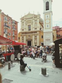 People on street in city against sky