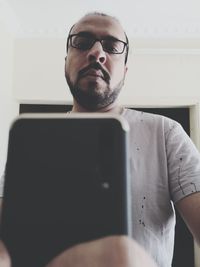 Young man using mobile phone at home