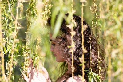 Portrait of young woman with plants