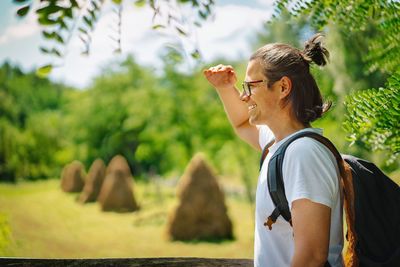 Side view of young man with backpack at countryside