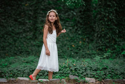 Full length portrait of happy woman standing on land