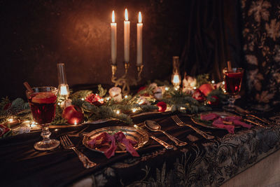 Christmas academia vintage romantic table with fir, candles, mulled wine, red decorations