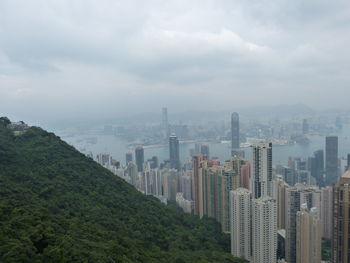 View of cityscape against cloudy sky