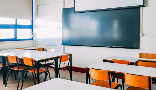 Lecture room or school empty classroom with desks 