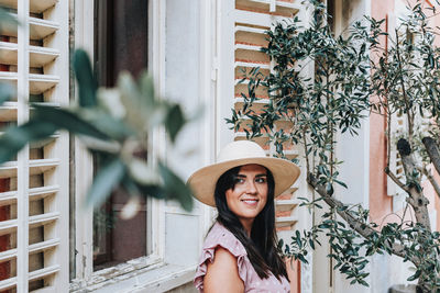 Portrait of smiling young woman against plants