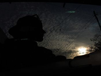 Silhouette man photographing against sky during sunset