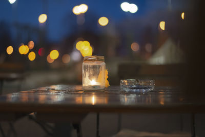 Close-up of illuminated tea light candles on table in restaurant