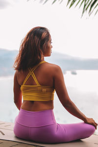 Side view of woman sitting on beach