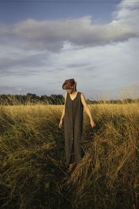 Mysterious woman in dress walks on the field