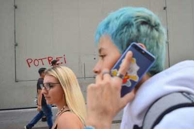 Portrait of a smiling young woman holding smart phone