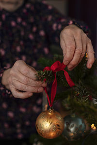 Woman's hands decorating christmas tree