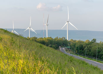 Windmills on field against sky