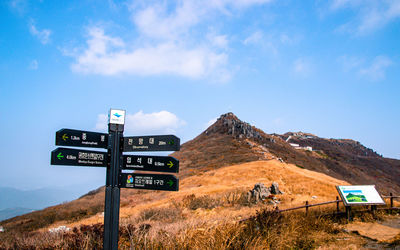 Low angle view of road sign against sky