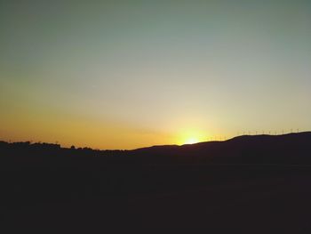 Scenic view of silhouette landscape against clear sky during sunset