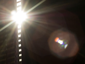 Close-up of illuminated lamp against bright sun