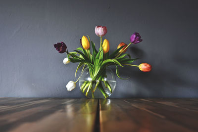 Close-up of flower vase on table against wall