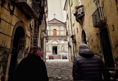 Rear view of people walking outside building