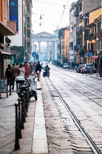 People on street amidst buildings in city