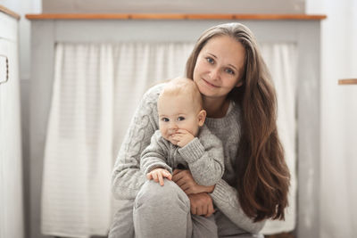 Portrait of young woman sitting on sofa at home