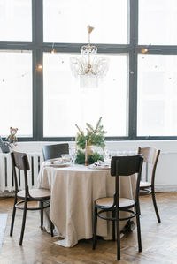 A dining table with wooden chairs, decorated and served for christmas dinner 