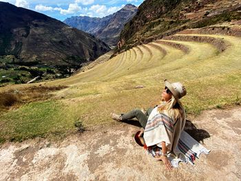 Woman sitting on landscape with mountain range