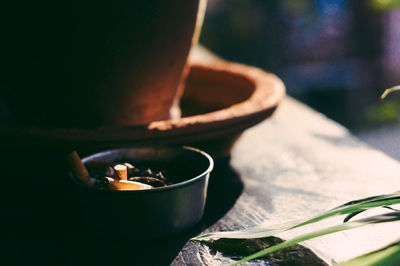 High angle view of cigarette butts in bowl on table