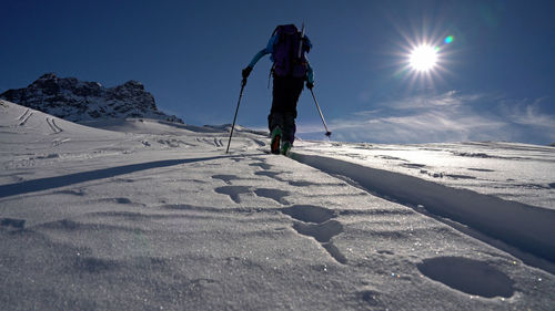 Man skiing on snowcapped mountain against sky