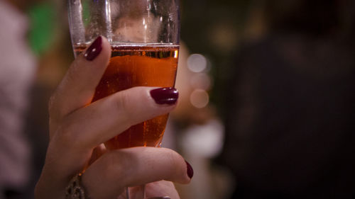 Close-up of hand holding beer glass