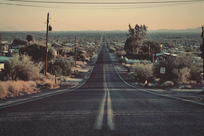 Empty road against sky in city