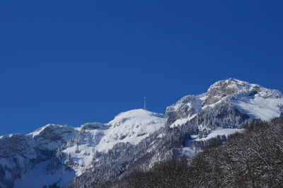 Scenic view of snowcapped mountains against clear blue sky