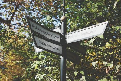 Low angle view of information sign against trees