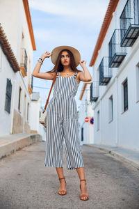 Young woman standing against wall