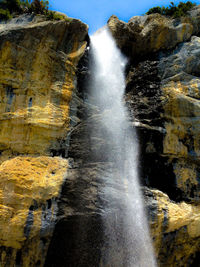 Scenic view of waterfall against sky